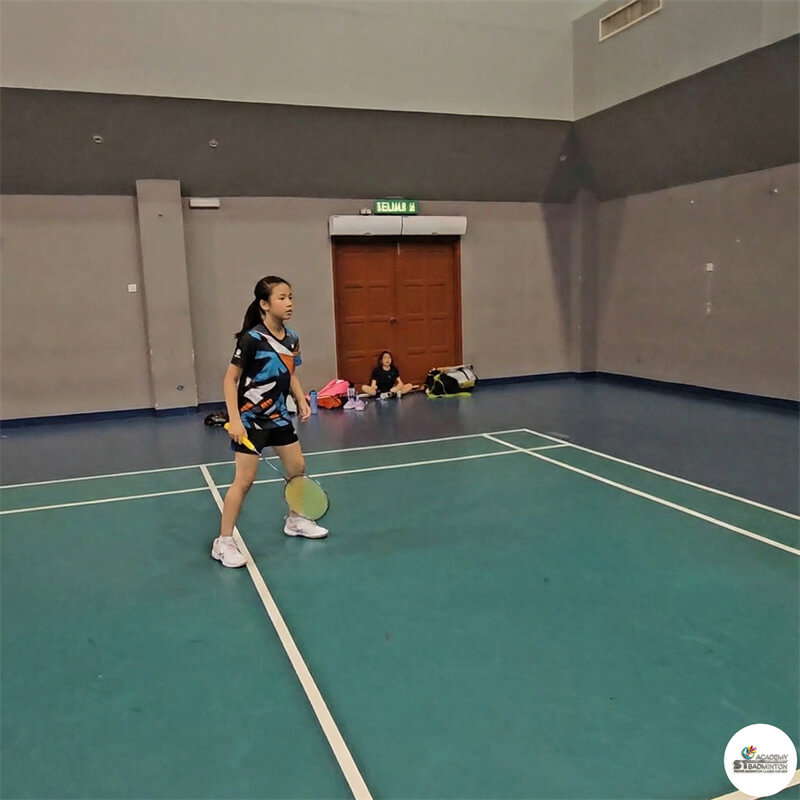 Junior badminton student learning serve and return patterns during PBF Level 1 class in KL