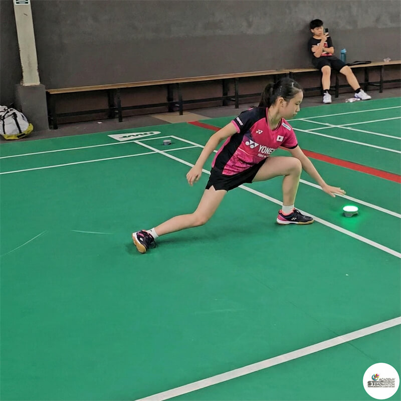 Student receiving feedback on grip and footwork during PBF Level 1 badminton foundation training in Malaysia