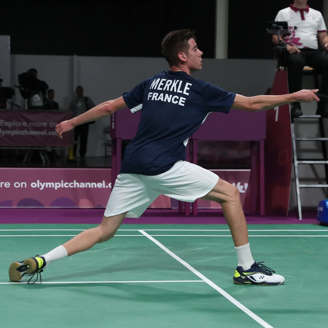 Arnaud Merkle lunge technique Arnaud Merkle in a deep forehand lunge at the net, seen from behind, at the 2018 Youth Olympic Games