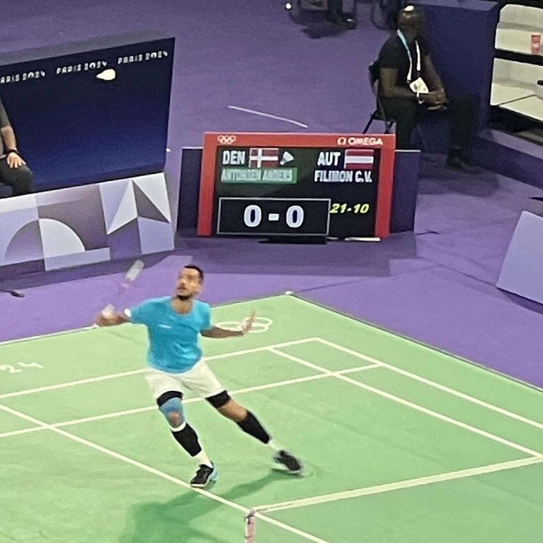Collins Valentine Filimon playing Anders Antonsen at the Paris 2024 Olympic Games (real photo, Wikimedia Commons, CC BY-SA 4.0) Collins Valentine Filimon playing Anders Antonsen at the Paris 2024 Olympic Games (real photo, Wikimedia Commons, CC BY-SA 4.0)
