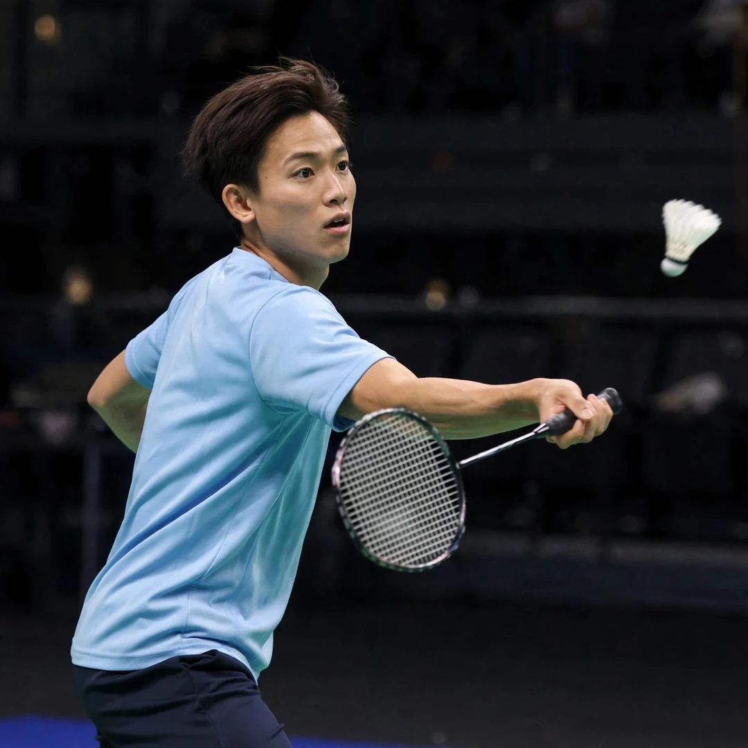 Riki Takei Japan professional badminton player men's singles in action Riki Takei of Japan playing a forehand drive in his light blue Japan kit (AI-generated)