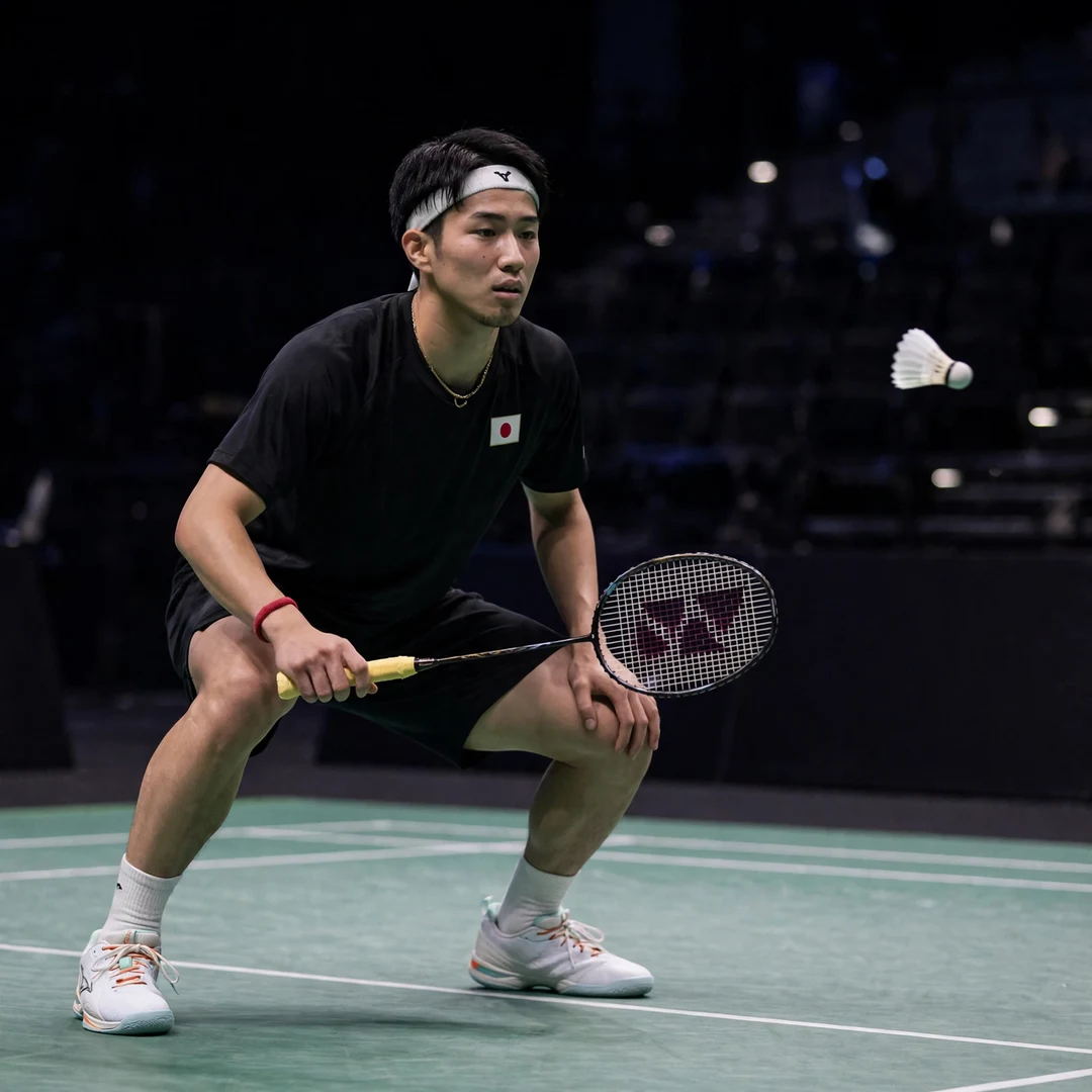 Shogo Ogawa defensive crouch Shogo Ogawa in a low defensive crouch, racket in his right hand and left hand resting on his knee (AI-generated)