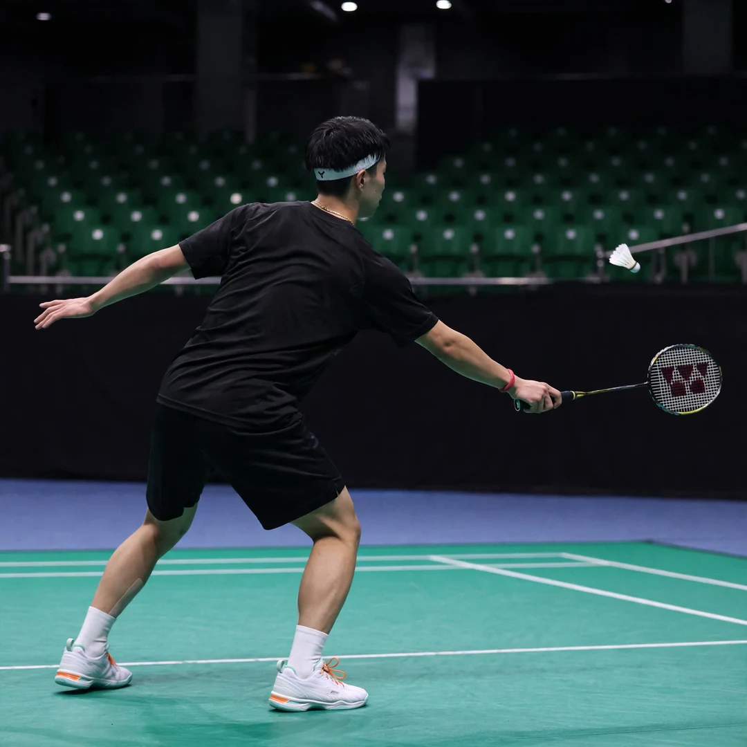 Shogo Ogawa playing style Shogo Ogawa playing a cross-court forehand drive from the rear court, seen from behind, racket in his right hand (AI-generated)